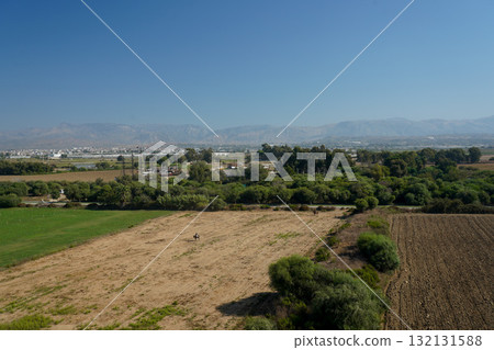 A Scenic Landscape Featuring Amber Fields and Verdant Flora Under a Clear Sky, Showcasing the Beauty of Nature's Serenity and Agricultural Harmony 132131588