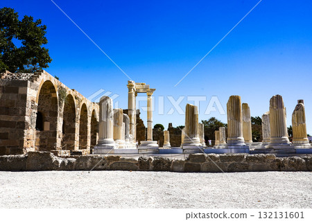 Exploring Ancient Ruins and Well-Preserved Columns Under a Clear Blue Sky in a Historic Archaeological Site 132131601