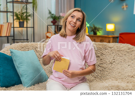 Pregnant woman writing future letter for baby placing envelope on belly smiling hopeful sweet hope 132131704
