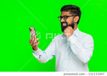 Indian man holding smartphone looking excited celebrating win jackpot lottery mobile game happy news 132131847