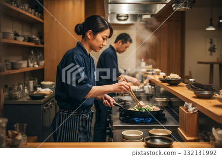 Serious profile of a female chef cooking in a Japanese-style kitchen 132131992