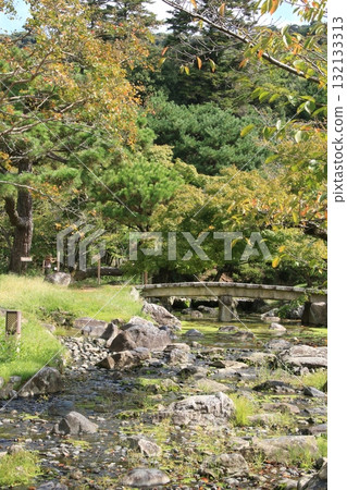 A view of the river and bridge flowing through Maruyama Park in Kyoto 132133313