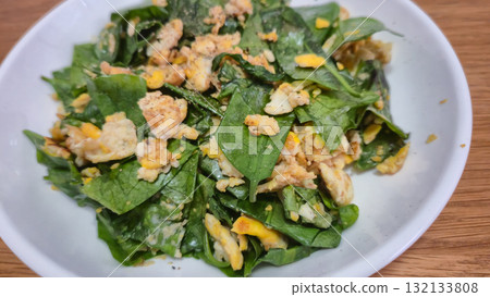 closed up of Stir-fried Malindjo Leaves with Egg on white plate on wooden table Thai food closed up of Stir-fried Malindjo Leaves with Egg on white plate on wooden table Thai food 132133808