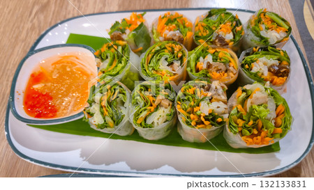 Fresh vegetable spring rolls with dipping sauce on a plate for appetizer Fresh vegetable spring rolls with dipping sauce on a plate for appetizer 132133831