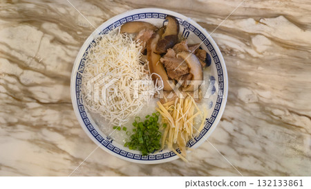 Bowl of rice porridge with mushrooms, shredded ginger, and green onions on marble table Bowl of rice porridge with mushrooms, shredded ginger, and green onions on marble table 132133861