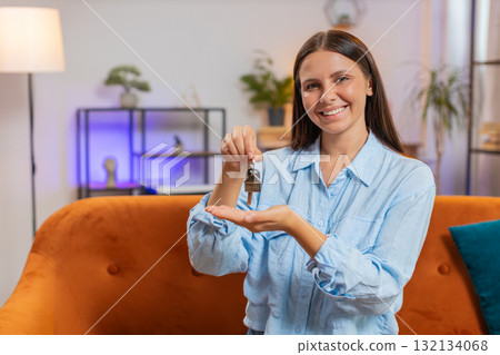 Happy woman real estate agent lifting hand showing the keys of new home buying or renting property 132134068