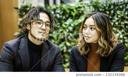 Thoughtful Young Professionals Engaged in Conversation in a Modern Green Office Space Thoughtful Young Professionals Engaged in Conversation in a Modern Green Office Space 132134366
