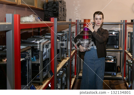 female engineer carries a plastic wire for a 3D printer in her hands. 132134801