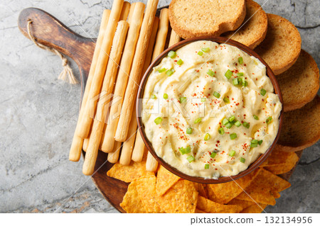 Homemade Deviled Egg Dip sauce with chips, breadsticks and biscuit close-up in a plate. Horizontal top view Homemade Deviled Egg Dip sauce with chips, breadsticks and biscuit close-up in a plate. Horizontal top view 132134956
