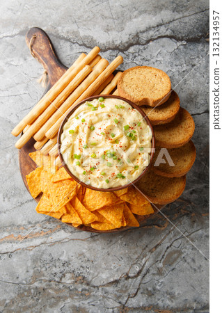 Deviled Egg Dip with chips, breadsticks, and a biscuit close-up in a plate. Vertical top view 132134957