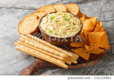 Homemade Deviled Egg Dip sauce with chips, breadsticks and biscuit close-up in a plate. Horizontal 132134961
