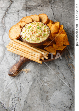 Deviled Egg Dip with chips, breadsticks, and a biscuit close-up in a plate. Vertical 132134963