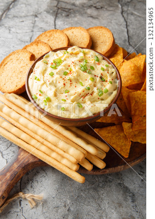 Tasty Deviled Egg Dip with nachos, breadsticks, and toast close-up in a plate. Vertical Tasty Deviled Egg Dip with nachos, breadsticks, and toast close-up in a plate. Vertical 132134965