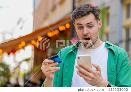 Shocked angry man trying to pay online shopping with smartphone blocked credit card lack of money Shocked angry man trying to pay online shopping with smartphone blocked credit card lack of money 132135090