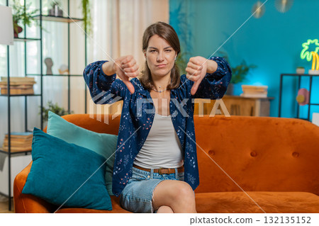 Upset unhappy young woman showing thumbs down sign dislike gesture disapproval bad work feedback 132135152