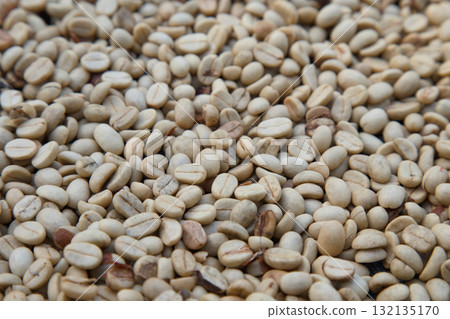 Close-up of raw green coffee beans before roasting, natural texture and organic farming concept for specialty coffee production and agriculture background. coffee industry. Close-up of raw green coffee beans before roasting, natural texture and organic farming concept for specialty coffee production and agriculture background. coffee industry. 132135170
