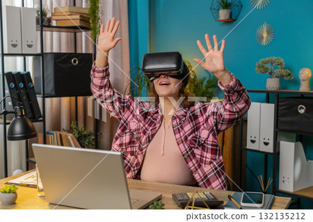 Business woman using virtual reality online VR app headset to simulation 3D at home office workplace 132135212