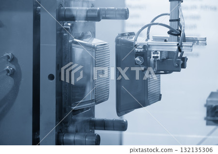 Close up scene material handling process the food container by robotic system from injection machine. Close up scene material handling process the food container by robotic system from injection machine. 132135306