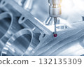 The multi axis CMM machine measuring the aluminum cylinder block parts in the light blue scene 132135309
