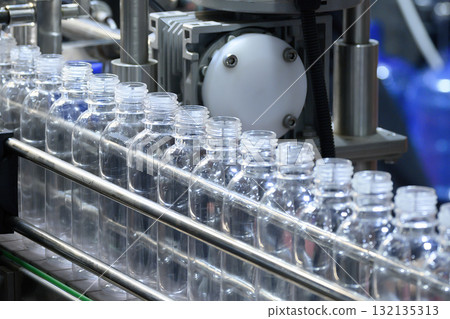 The automatic drinking water bottle filling process in the blue tone scene. The automatic drinking water bottle filling process in the blue tone scene. 132135313