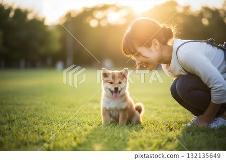 夕陽下草地上的微笑：一位女士和她的豆柴犬 132135649