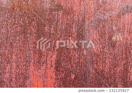 Texture of Worn red painted surface with scratches and discoloration, showing signs of age and use. 132135927