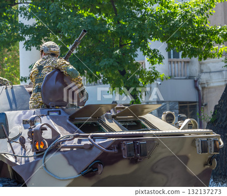 Soldier operating military vehicle in urban display 132137273
