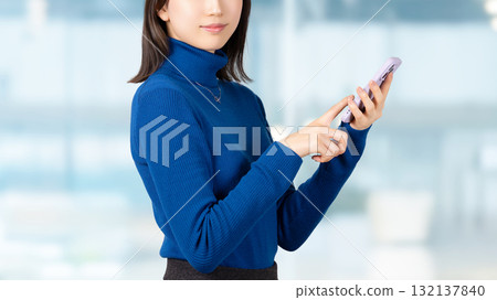 Smiling woman/businesswoman using a smartphone Smiling woman/businesswoman using a smartphone 132137840