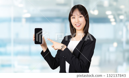 A woman/businesswoman pointing at a smartphone screen A woman/businesswoman pointing at a smartphone screen 132137843