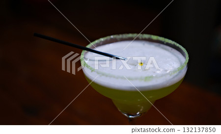 Margarita in a blue rimmed glass with lime on a wooden surface Margarita in a blue rimmed glass with lime on a wooden surface 132137850