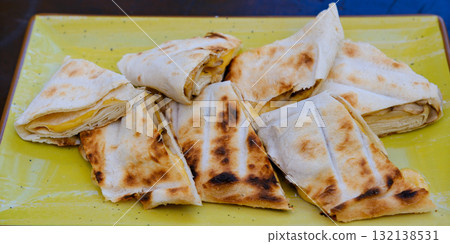 Grilled quesadillas on wooden board and with salsa and guacamole on stone background. Mexican cuisine concept Quesadilla wrap with chicken and corn. Top view 132138531