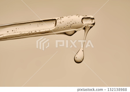 Serum in a pipette close-up on a beige background. Serum in a pipette close-up on a beige background. 132138988