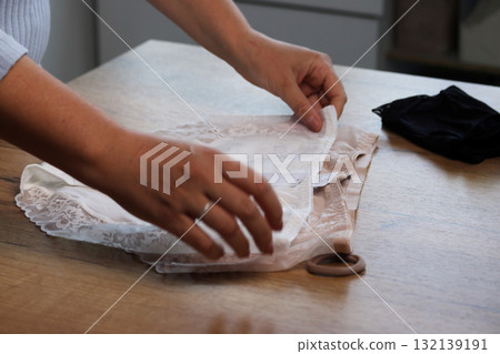 Woman reviewing a set of panties Spreading them out on a table 132139191