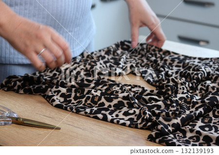 Woman reviewing leopard print pants Woman reviewing leopard print pants 132139193