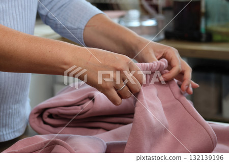 Woman reviewing a pink tracksuit Demonstrating the sleeve Woman reviewing a pink tracksuit Demonstrating the sleeve 132139196