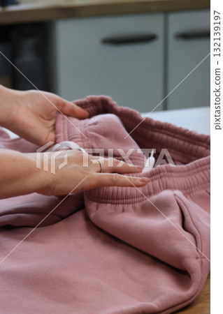 Woman reviewing a pink tracksuit Demonstrating the pants Woman reviewing a pink tracksuit Demonstrating the pants 132139197