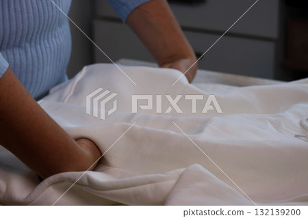 Woman reviewing a white hoodie Checking the pockets 132139200