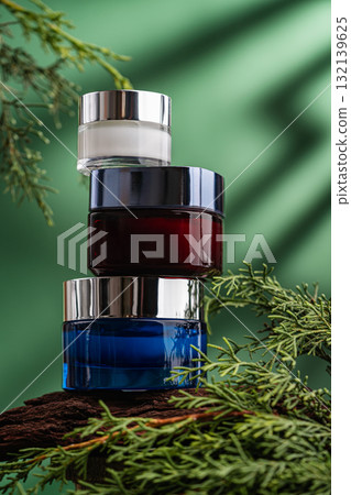 Stack of colorful cosmetic jars on wood with green natural background 132139625