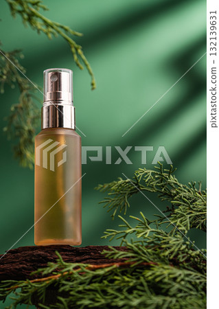 Golden cosmetic spray bottle on wood with green leaves and natural light Golden cosmetic spray bottle on wood with green leaves and natural light 132139631