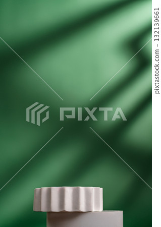 Minimal white podium on green background with natural shadows Minimal white podium on green background with natural shadows 132139661