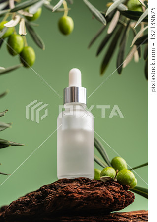 Natural facial serum with olive branches and green background in minimalist composition Natural facial serum with olive branches and green background in minimalist composition 132139675