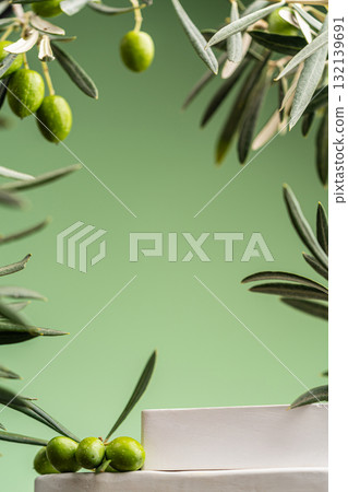 Olive branches with green olives on minimalist pedestal and green background 132139691