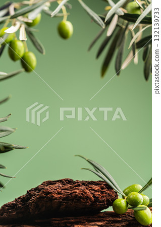 Olive branches and wooden podium on green background, natural cosmetic scene Olive branches and wooden podium on green background, natural cosmetic scene 132139733