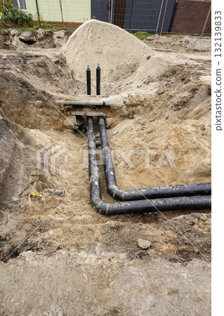 Construction site showing new underground piping installation in a recently excavated area 132139833
