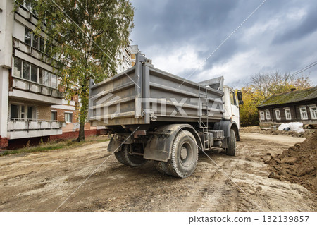 Truck parked on a construction site near residential buildings during an overcast afternoon 132139857