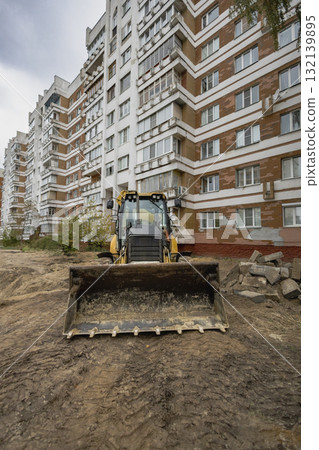 Construction site in urban area with a bulldozer preparing the ground for building renovation Construction site in urban area with a bulldozer preparing the ground for building renovation 132139895