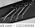 Steel spanners are laid out in ascending order of diameter on a rubber napkin. Hand tools arrangement in order stock photo 132140088