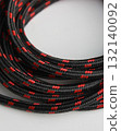 Pattern of strong cord made of fabric fibers laid in a circle. Rope for domestic and tourist needs close up view 132140092