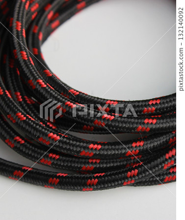 Pattern of strong cord made of fabric fibers laid in a circle. Rope for domestic and tourist needs close up view 132140092