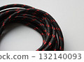 Part of a circular winding of cable with a synthetic braided protective layer. Cable and wire detailed stock photo 132140093
